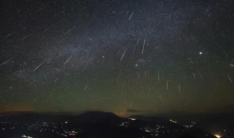 Rastros luminosos de meteoros atravessam o céu noturno durante uma chuva de meteoros.